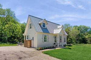 a white house with a gambrel roof at Eco-Chic Lake Somerville Area Farmhouse w/ Porch in Brenham