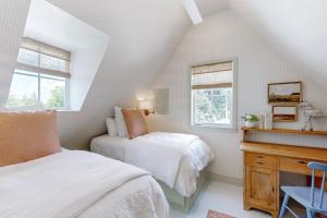 two beds in a attic bedroom with two windows at Off-Grid & Elegant Farmhouse Near Somerville Lake in Brenham