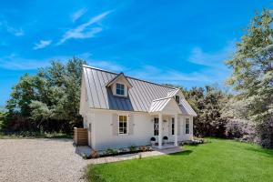 a white house with a gambrel roof at Off-Grid & Elegant Farmhouse Near Somerville Lake in Brenham