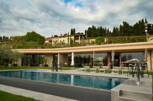 ein Haus mit einem Pool neben einem Gebäude in der Unterkunft La Cipressina B&B in Cavaion Veronese