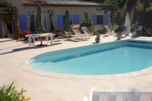 a swimming pool in a yard with a table and chairs at VILLA HIBISCUS in Callian