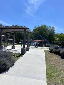 um parque infantil com um escorrega azul num parque em Casa cañadas. Amplia, cómoda y hermosa. em La Cañada