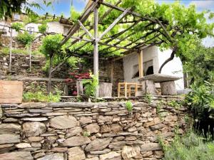eine Steinmauer vor einem Steinhaus in der Unterkunft 4 bedrooms house with furnished terrace and wifi at Agios Lavrentios in Agios Lavrentios