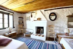 ein Wohnzimmer mit einem Kamin und einem Bett sowie ein Zimmer in der Unterkunft 4 bedrooms house with furnished terrace and wifi at Agios Lavrentios in Agios Lavrentios