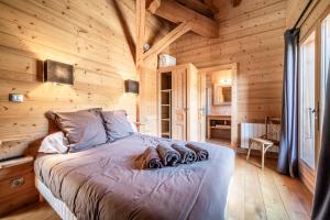 a bedroom with a bed in a wooden cabin at Chalet L'aube claire - 5 étoiles in Morzine