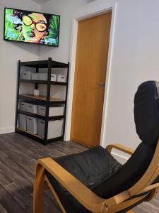 a living room with a chair and a tv at DE1 Studio Apartment Heart of City in Derby