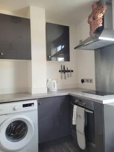 a kitchen with a washer and a washing machine at DE1 Studio Apartment Heart of City in Derby