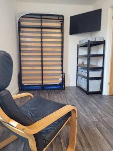 a rocking chair in a room with a television at DE1 Studio Apartment Heart of City in Derby