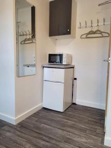 a small kitchen with a microwave and a refrigerator at DE1 Studio Apartment Heart of City in Derby