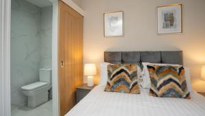 a bedroom with a bed with a toilet and two pillows at Luxury 1 BDR City Apartments by Belfast City Breaks in Belfast