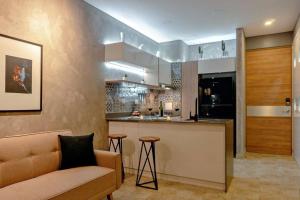 Una sala de estar con un sofá y una cocina. en Moderno Apartasuite en Gaira, en Santa Marta