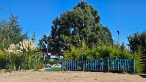 a blue fence in front of a tree at Las palmeras de Colbún in Colbún