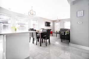 a kitchen and living room with a table and chairs at The Maid of the Mist Villa- With Private Yard & Parking, Minutes From Falls & Casino by Niagara Hospitality in Niagara Falls