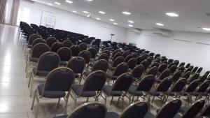 an empty lecture hall with chairs in it at Colonial Flat Hotel in Itapetininga +37 photos