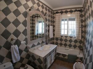 Un baño con lavabo, espejo y bañera. en Casa Maleda, en Hornachuelos 29 fotos más
