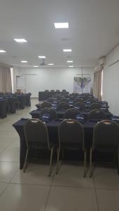 a room with a long table with chairs in it at Colonial Flat Hotel in Itapetininga