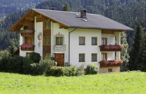 a house on the side of a hill with flowers at Hotel Garni Haus Anita in Liesing