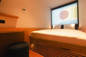 a bedroom with a bed and a large screen at Poppies in Amsterdam