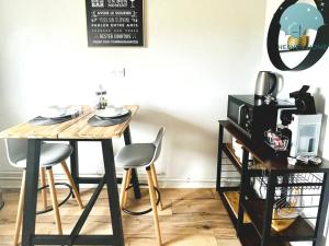 a dining room table with two chairs and a microwave at Charmant appartement proche des commerces et Gare in Saint-Brieuc