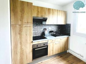 a kitchen with wooden cabinets and a stove top oven at Charmant appartement proche des commerces et Gare in Saint-Brieuc +9 photos