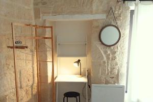 Zimmer mit einem Spiegel und einem Tisch mit einer Lampe in der Unterkunft Immeuble 3 Apparts Centre historique St Gilles MaisoncarreeConciergerie in Saint-Gilles