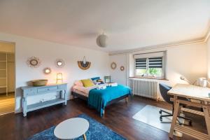 a bedroom with a bed and a desk and a table at Grande maison conviviale - pour 10 personnes in Pabu