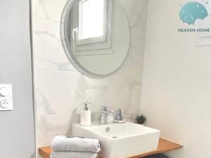 a bathroom with a white sink and a mirror at Agreable T2 proche des commerces et gare in Saint-Brieuc