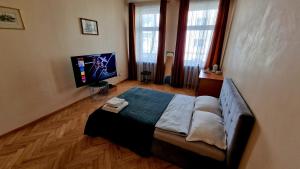 a bedroom with a bed and a flat screen tv at Kaunas Center Apartment in Kaunas