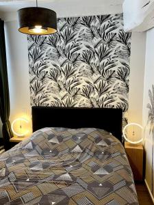a bedroom with a black and white patterned wall at Magnifique T2 coeur de ville Port a pieds in Paimpol