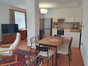 a kitchen and dining room with a table and chairs at Chalupa Pěkný den in Rudník