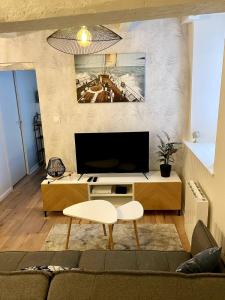 a living room with a flat screen tv on a wall at Magnifique T2 coeur de ville Port a pieds in Paimpol