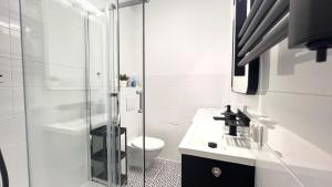 uma casa de banho com um chuveiro, um WC e um lavatório. em Prestige Apartments - Orłowska 40 - Studio em Gdynia