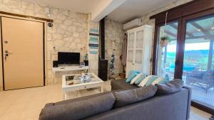 ein Wohnzimmer mit Sofa und Fernseher in der Unterkunft Maria's stone Heaven Retreat in Kalandra