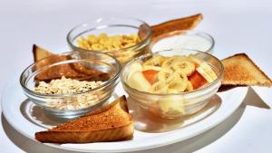 a plate with three bowls of food and toast at Dunas Club - Hotel & Apartamentos in Corralejo