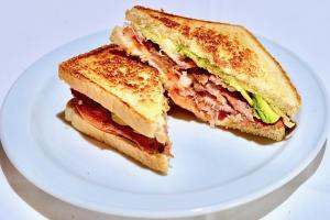 a sandwich cut in half on a white plate at Dunas Club - Hotel & Apartamentos in Corralejo