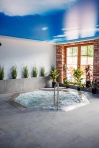 uma banheira de hidromassagem num quarto com plantas em Panorama Górska Wisła Resort & SPA em Wisla