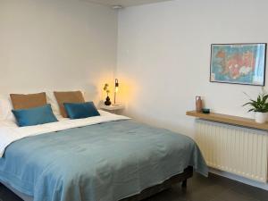 a bedroom with a large bed with blue pillows at Reykjavik city center - Privat studio apartment in Reykjavík