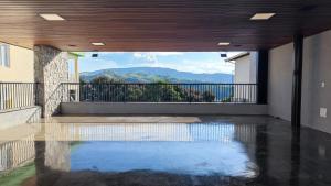 a swimming pool in the middle of a room with a balcony at Lake's House - Piscina natural aquecida in Socorro