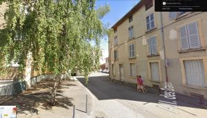 una persona caminando por una calle al lado de un edificio en Les Graveurs - Bourgoin-Jallieu - City Center, en Bourgoin