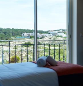 AmoreiraにあるPenthouse, vista mar e piscina, Praia del Rey, Óbidos, A12のベッドと大きな窓のある寝室