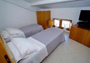 a bedroom with two beds and a flat screen tv at Dimora Mariagrazia in Rimini