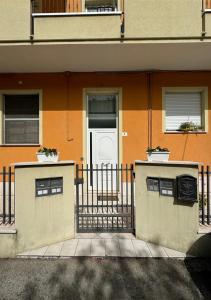 an orange building with a white door and a fence at Dimora Mariagrazia in Rimini