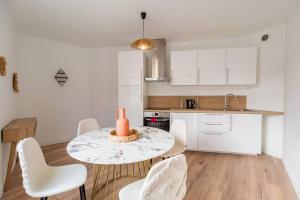 a kitchen with a table and chairs in a room at Elegant appartement 2chambres Cote de Granit Rose in Pleumeur-Bodou
