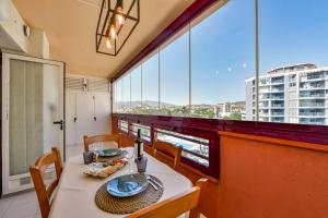 uma sala de jantar com mesa e cadeiras e janelas grandes em Apartment Beachfront 36 em Calpe