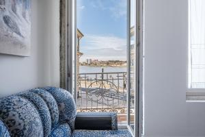 a room with a chair and a view of a balcony at GuestReady - Maria d'Afurada in Vila Nova de Gaia