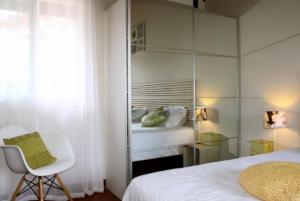 a bedroom with a bed and a chair and a mirror at Escalonia 2 in Las Terrenas