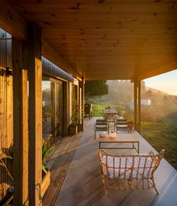 eine Terrasse mit Tischen und Stühlen auf einem Haus in der Unterkunft Doni Wood House, casa en la playa de Doniños in A Coruña