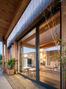 ein Haus mit Glasschiebetüren auf einer Terrasse in der Unterkunft Doni Wood House, casa en la playa de Doniños in A Coruña