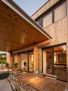 ein Haus mit einer Terrasse mit einem Tisch und Stühlen in der Unterkunft Doni Wood House, casa en la playa de Doniños in A Coruña + 24 Fotos