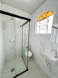 a bathroom with a glass shower and a sink at Elite Palace Hotel in Pará de Minas